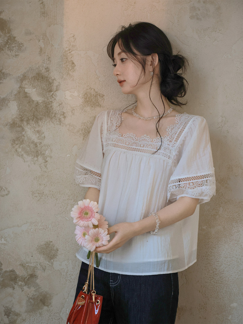 White lace short-sleeve blouse worn by a model