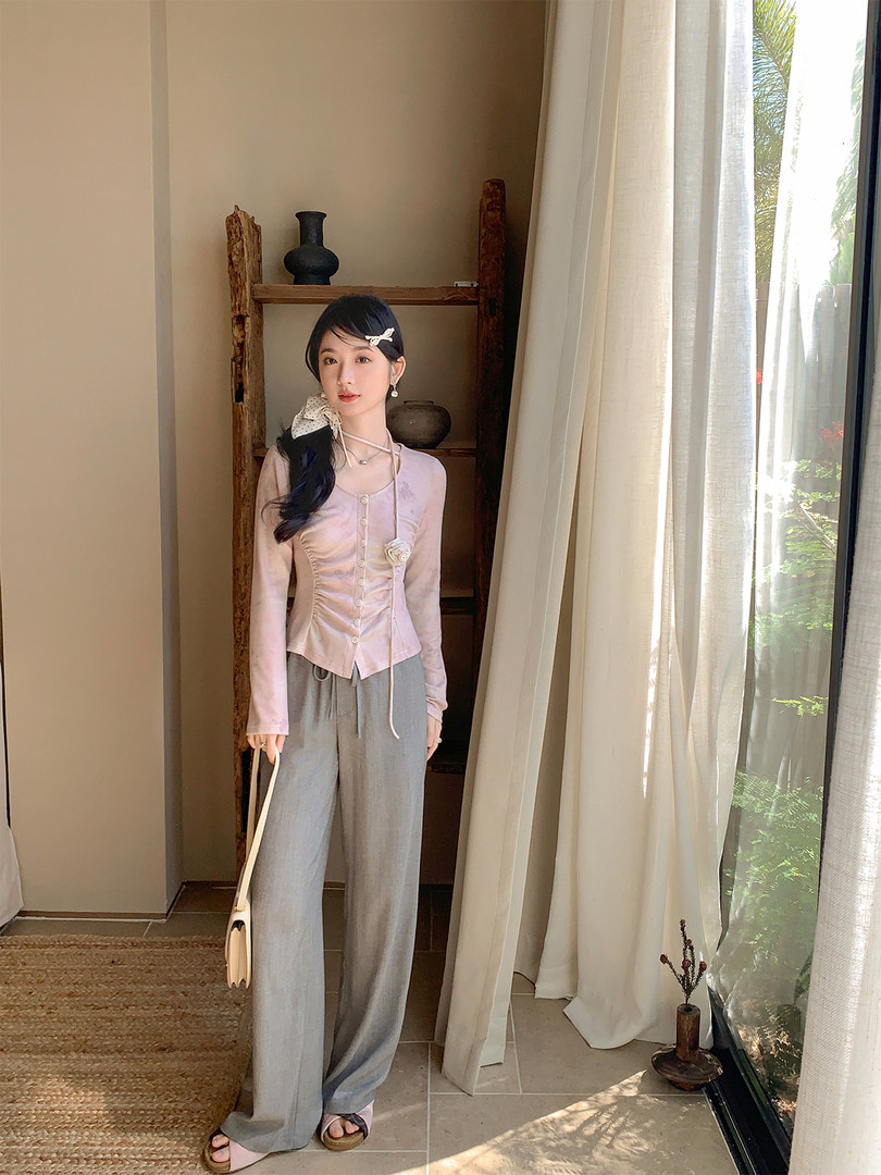 Model wearing a light pink button-front top with gray wide-leg pants