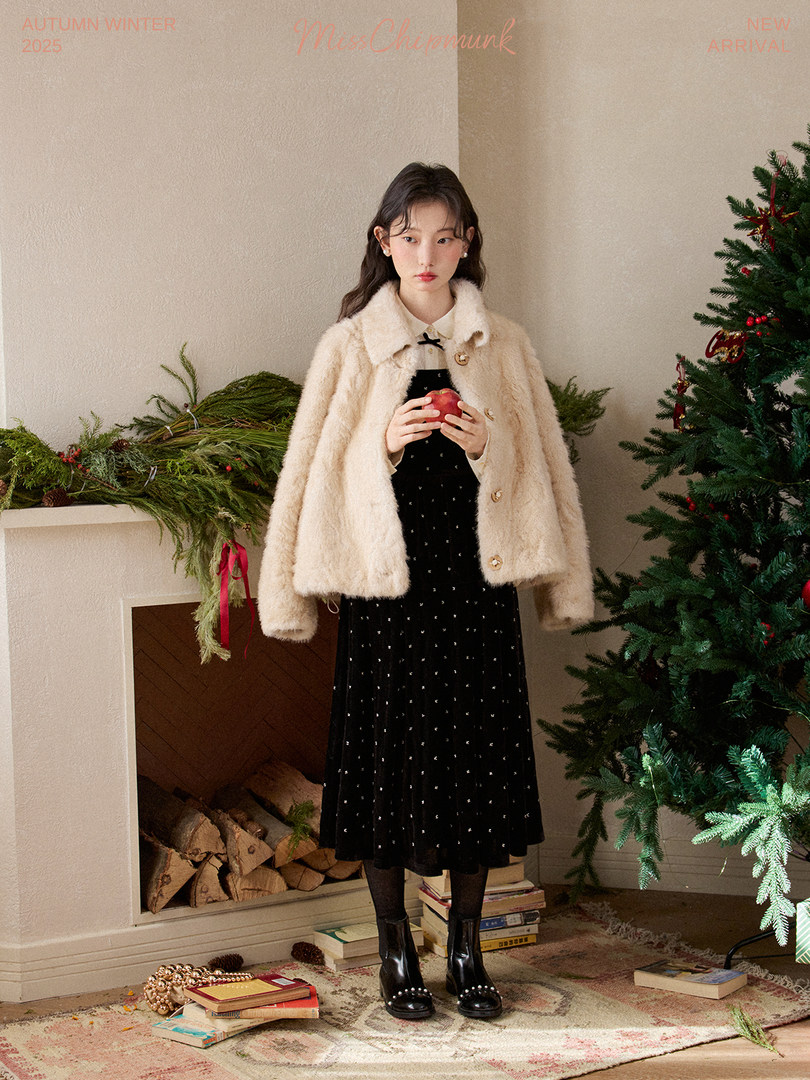 Model wearing a cream faux-fur coat over a black dress in a winter holiday setting