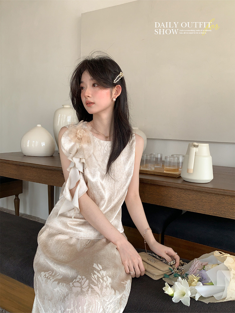 Cream satin sleeveless dress with a ruffled shoulder and floral pattern worn by a model