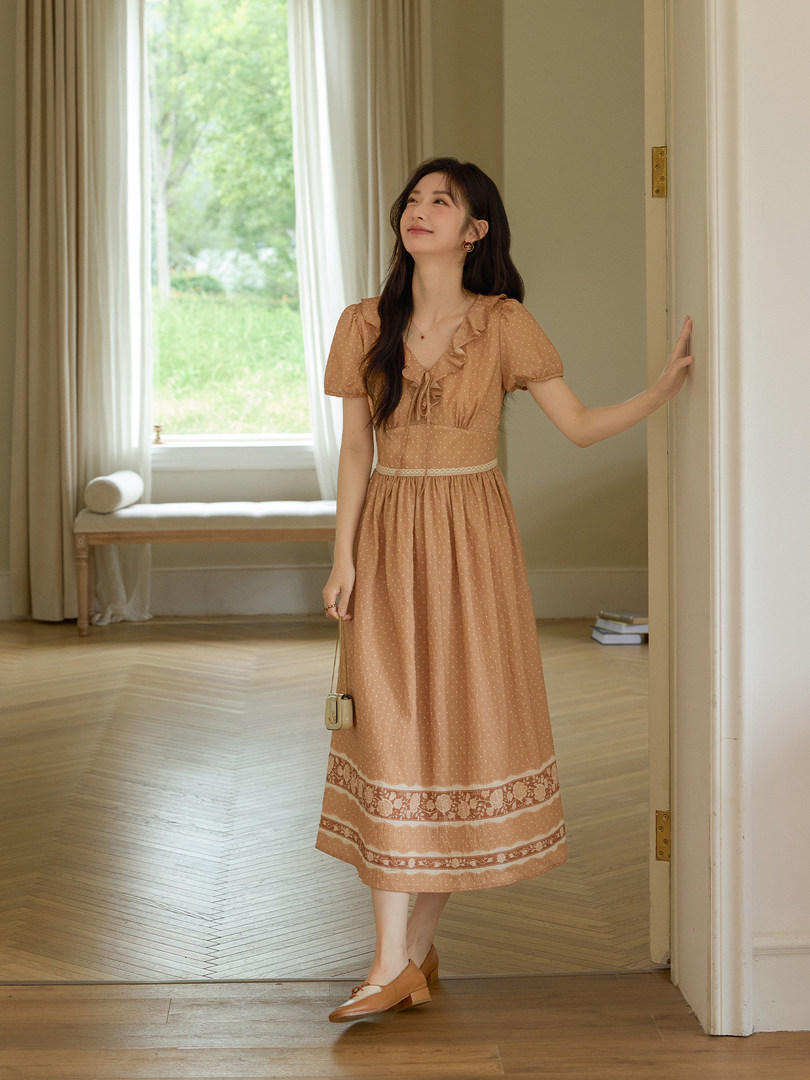 Woman wearing a peach ruffled midi dress indoors