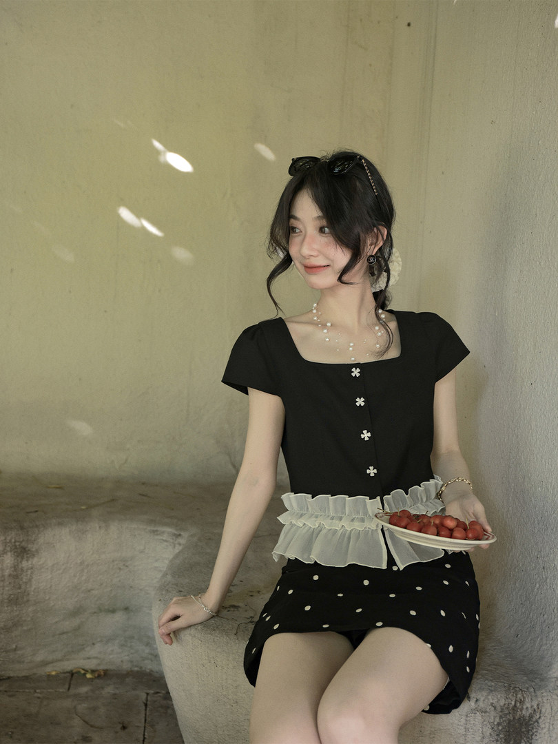 Black and white feminine dress worn by a model outdoors
