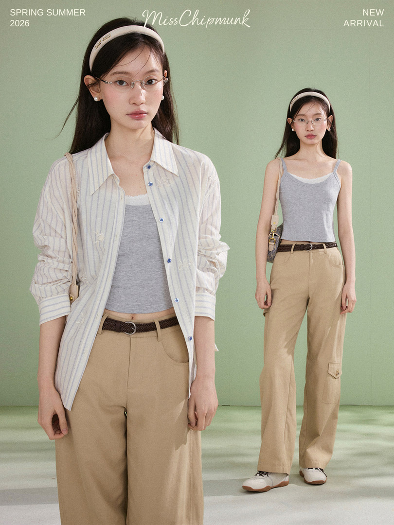 Female model wearing a striped shirt over a gray tank top with khaki pants