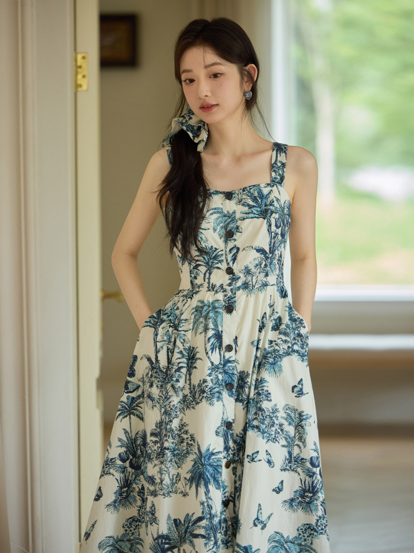 Woman wearing a blue tropical print sleeveless dress