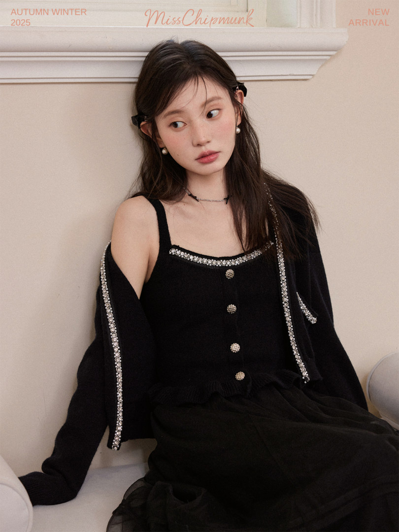 Model wearing a black embellished dress with matching cardigan