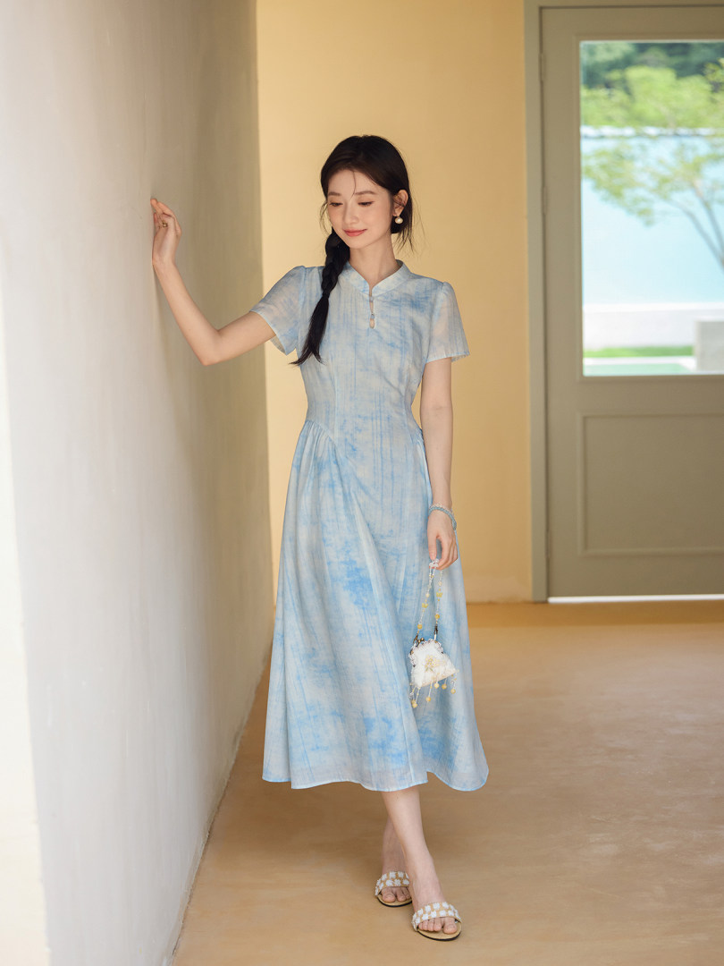 Model wearing a light blue tie-dye midi dress with short sleeves