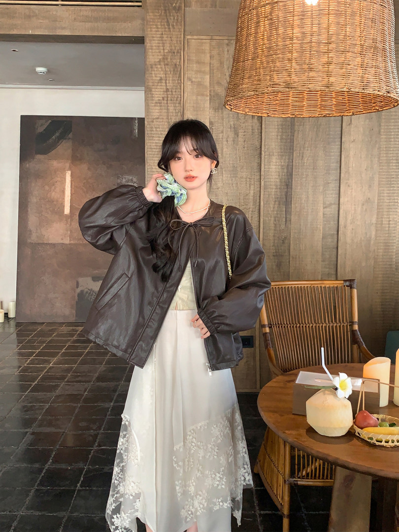 Woman wearing a dark brown oversized jacket over a white dress