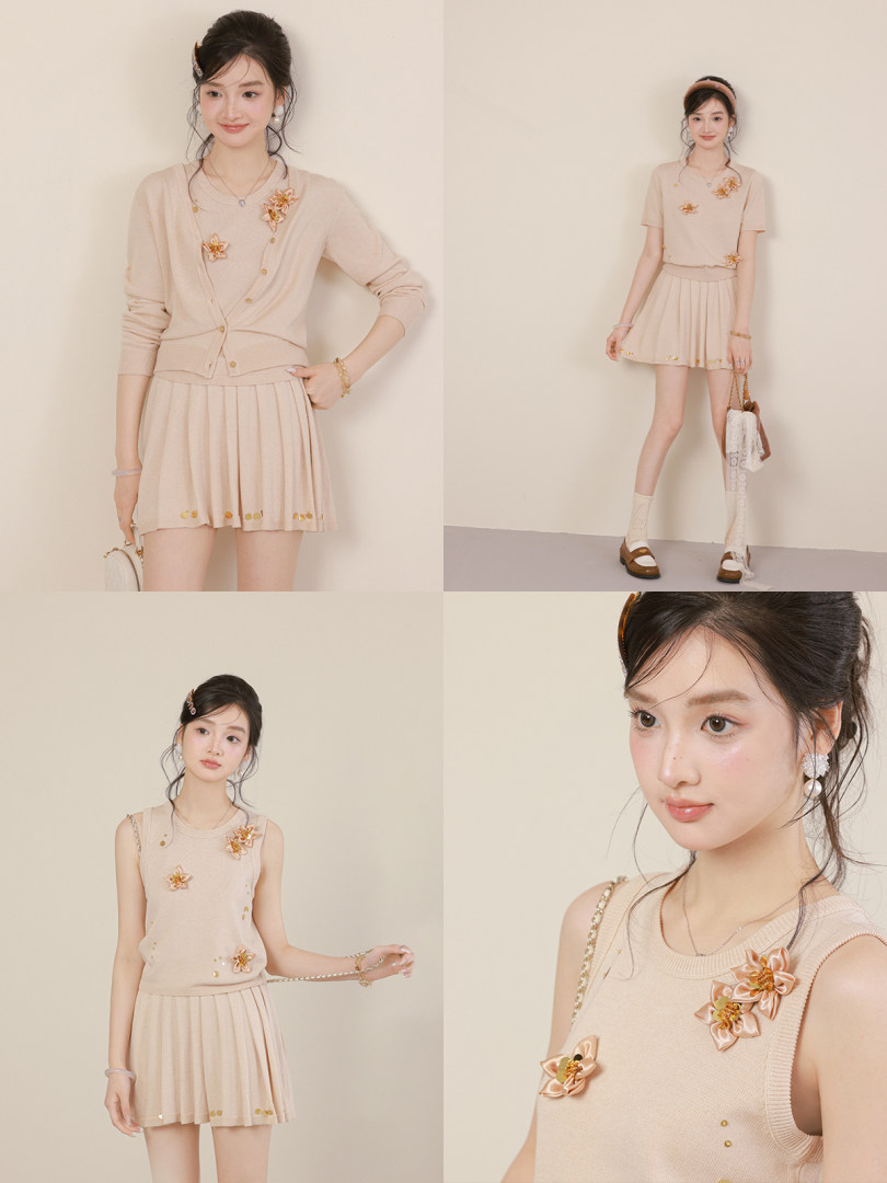 Model wearing a beige sleeveless knit top and pleated mini skirt outfit