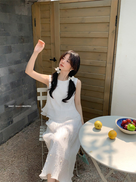 White sleeveless dress worn by a model outdoors