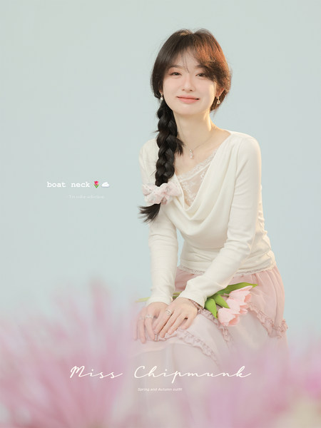 Woman wearing a white boat neck top with a pink skirt in a fashion promo image