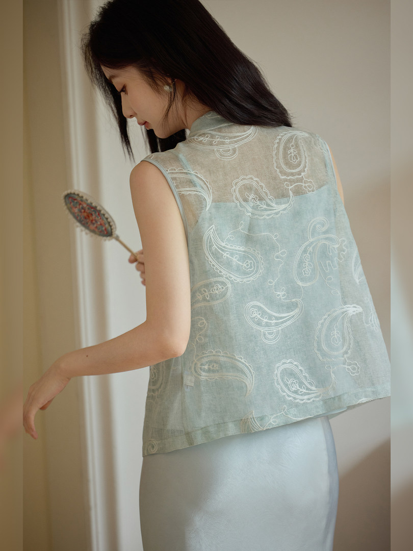 Model wearing a sheer light blue paisley sleeveless top