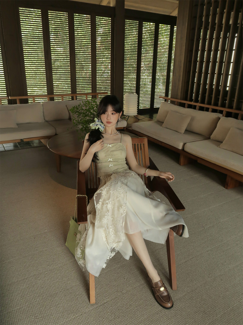 Woman wearing a light beige lace dress while seated indoors