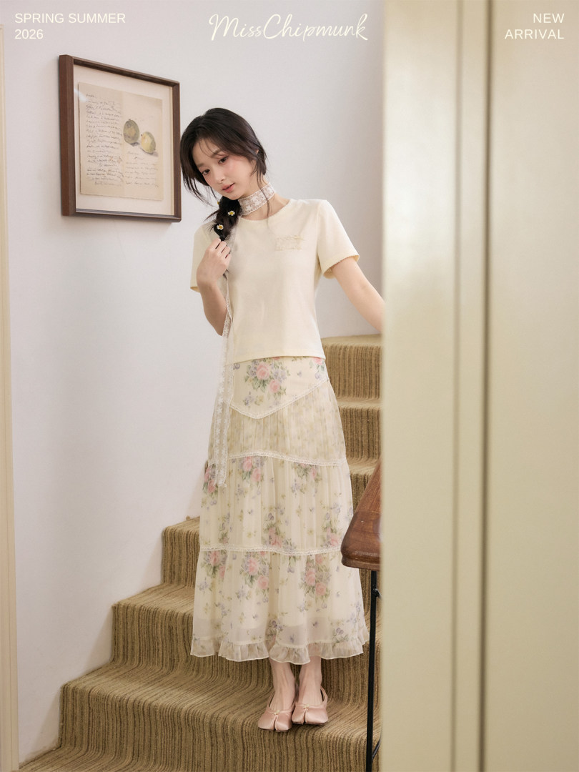 Model wearing a cream top with a floral tiered long skirt outfit