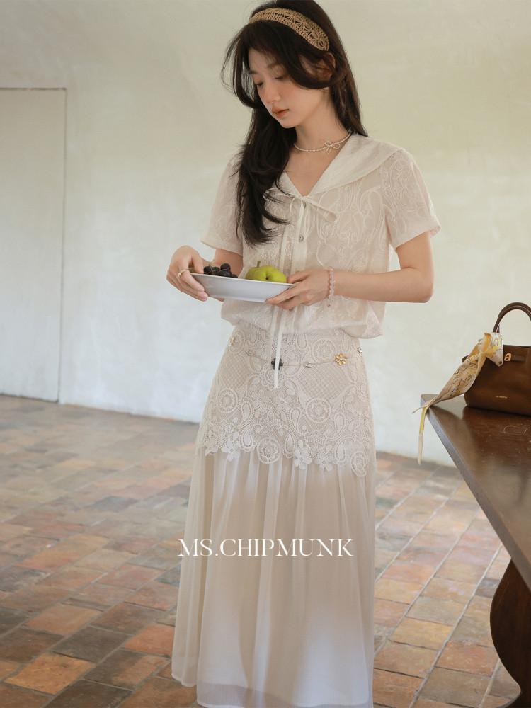 Model wearing a light lace blouse and matching sheer skirt set