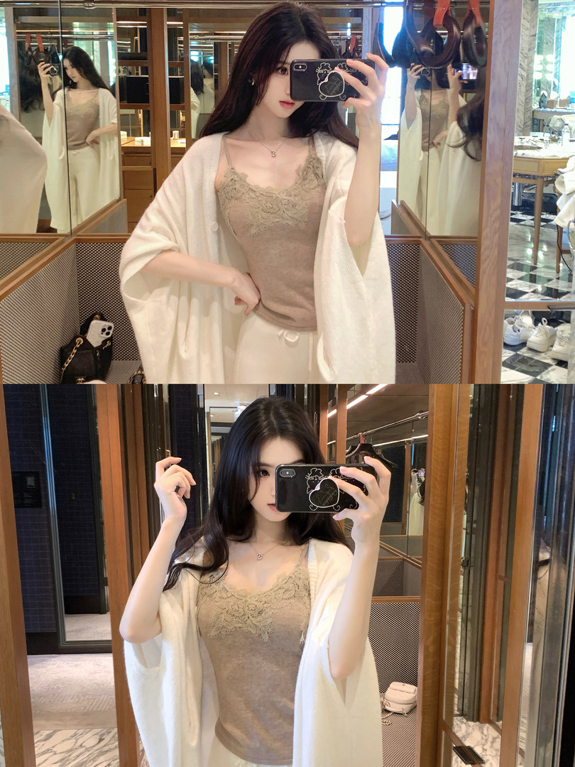 Woman taking mirror selfie wearing lace camisole and white cardigan