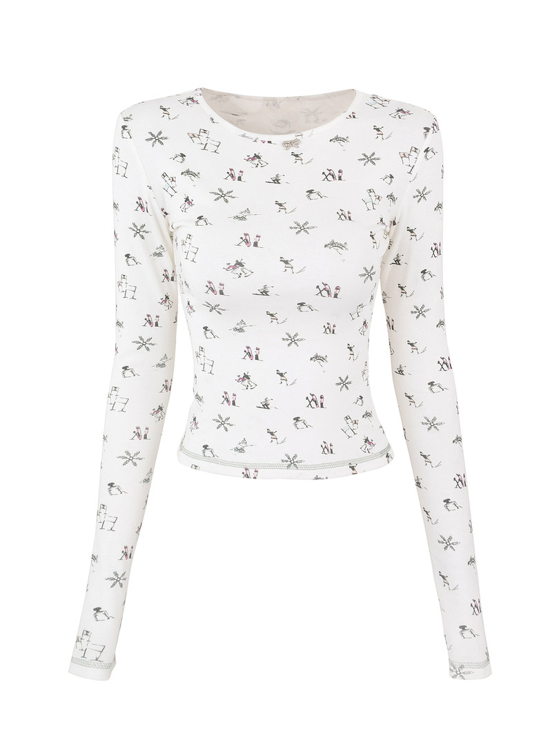 White long-sleeve crop top with winter-themed print including snowflakes and skiers