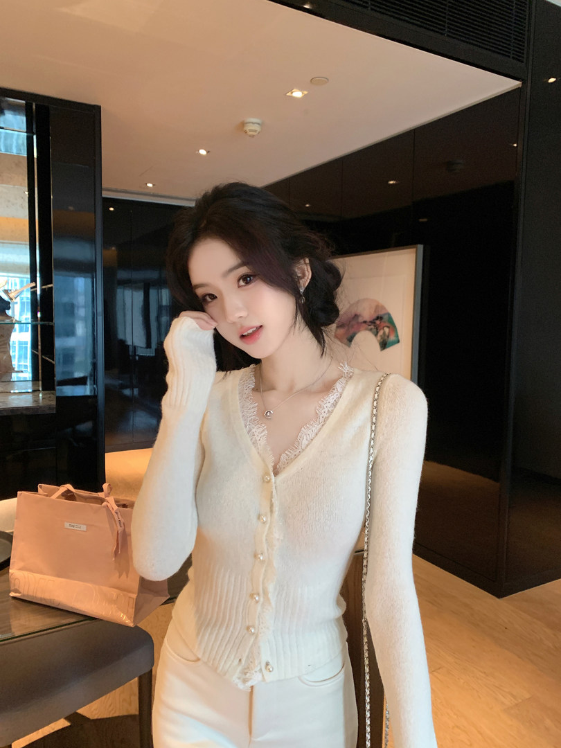 Woman wearing a cream-colored ribbed knit cardigan with lace trim and pearl buttons, paired with matching pants.