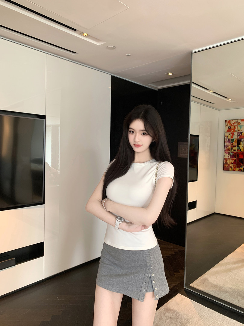 Woman wearing white short-sleeve top and gray button-front mini skirt in modern interior
