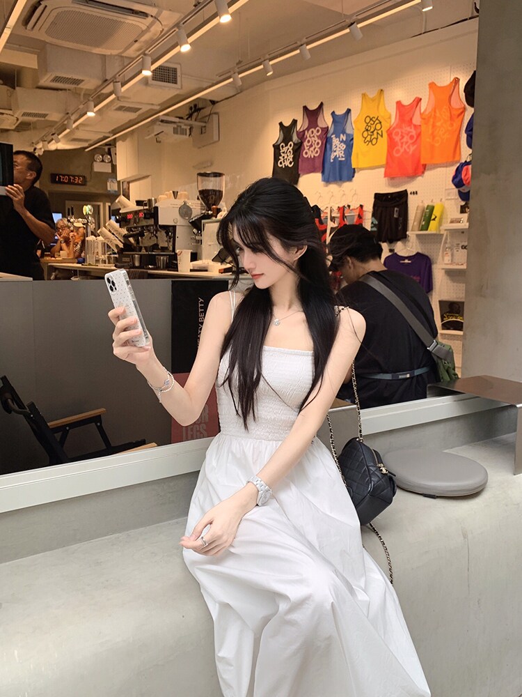 Woman wearing a white dress taking a selfie in a store