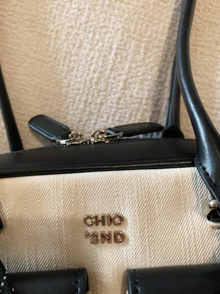Close-up of a black-and-beige handbag with CHIO '2ND logo