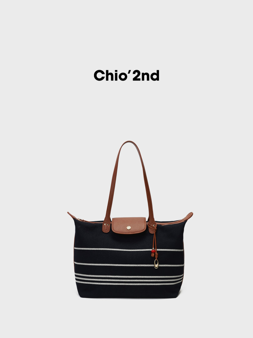 Black striped tote bag with brown leather handles on a white background