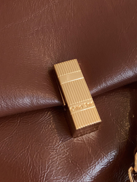 Close-up of a brown leather handbag with gold hardware