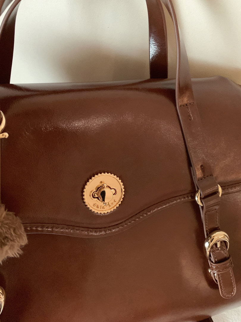 Brown leather handbag with gold hardware and shoulder strap