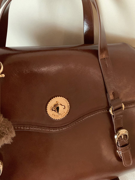 Brown leather handbag with gold hardware and shoulder strap