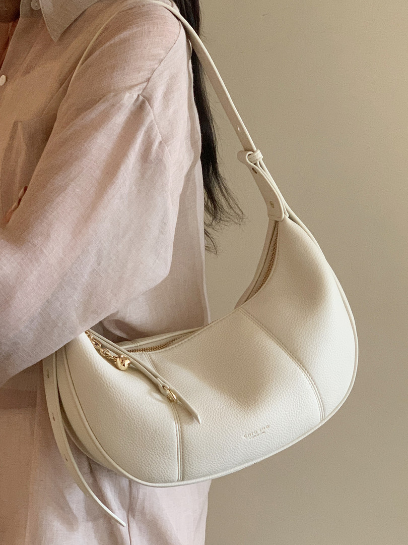 Cream textured shoulder handbag worn by a model