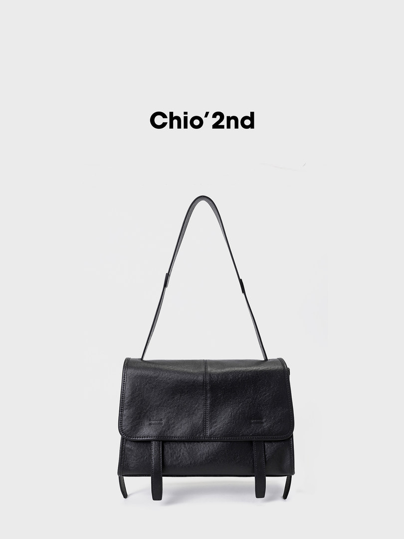 Black leather shoulder bag with flap closure on a white background