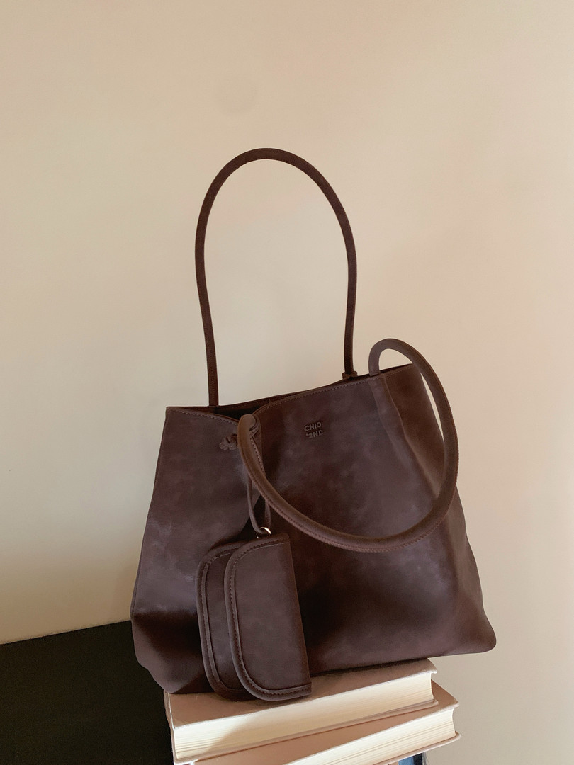 Brown leather tote handbag with long straps and a small front pouch