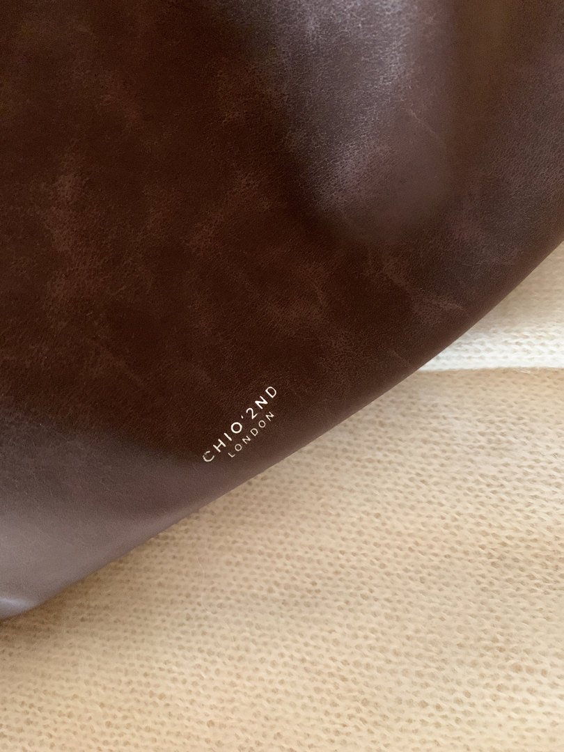 Close-up of a dark brown leather item with CHIO'2ND LONDON branding