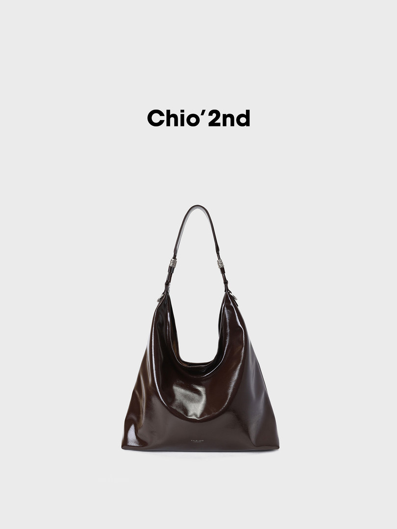 Dark brown glossy shoulder handbag on a plain background