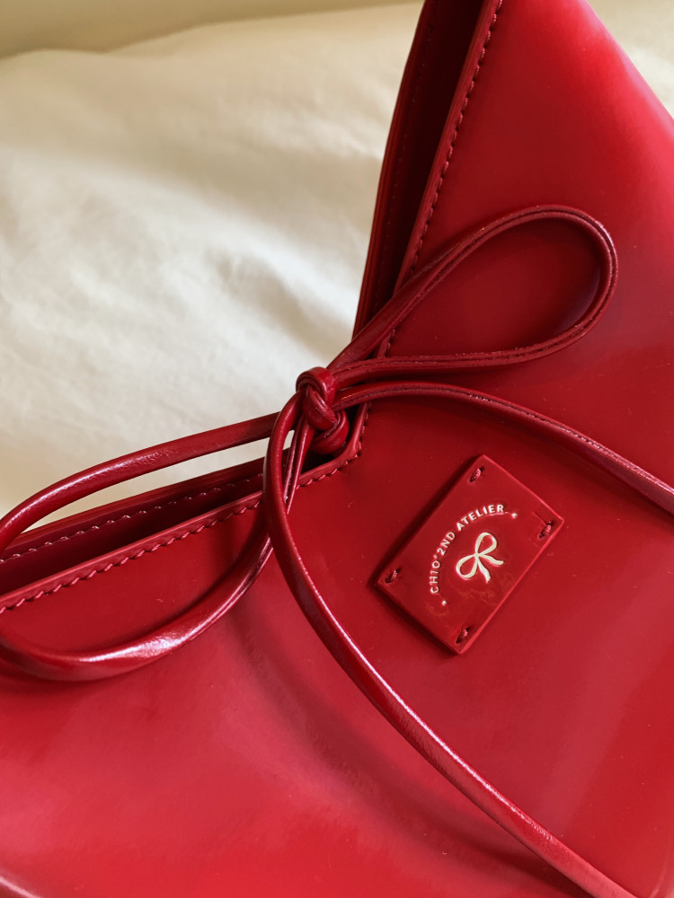 Red leather handbag with tie detail and logo plaque