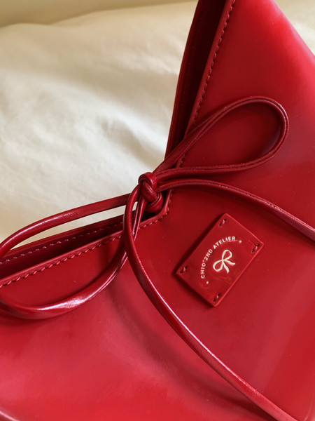 Red leather handbag with tie detail and logo plaque