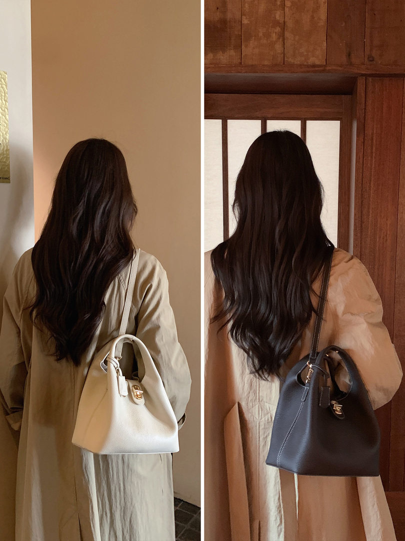 Two women wearing structured shoulder handbags in white and black