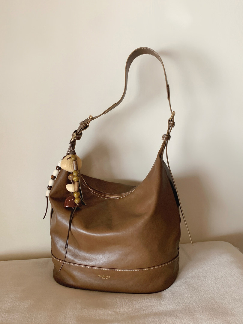 Brown leather shoulder handbag with decorative beaded charm