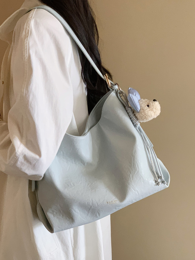 Light blue shoulder handbag worn by a model