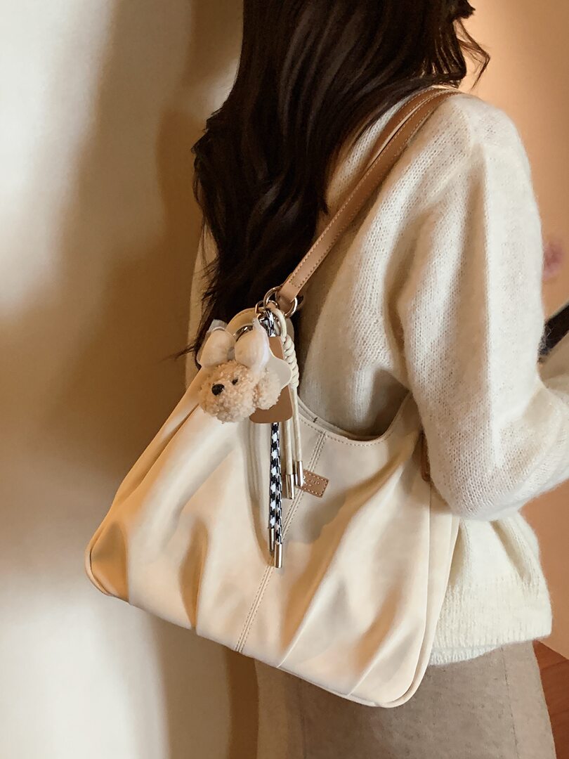 Beige shoulder tote bag worn by a woman