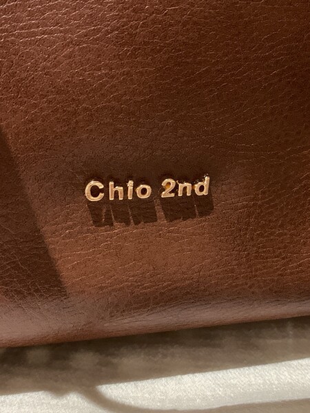 Close-up of a brown leather product with metallic brand lettering