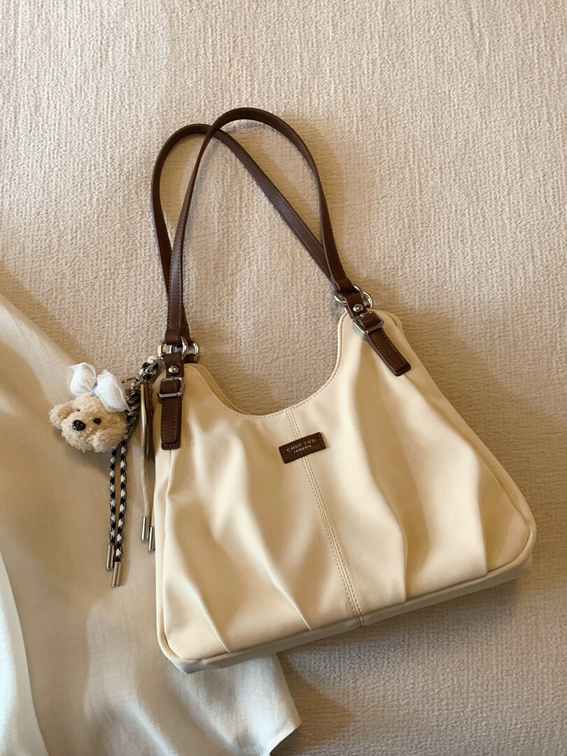 Cream leather shoulder handbag with brown straps and a teddy charm