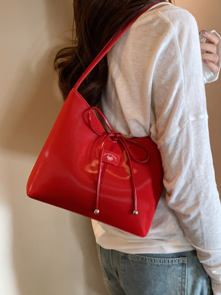 Red shoulder handbag worn on a model