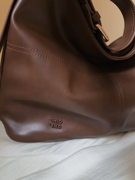 Brown leather handbag with gold hardware and stitched detailing