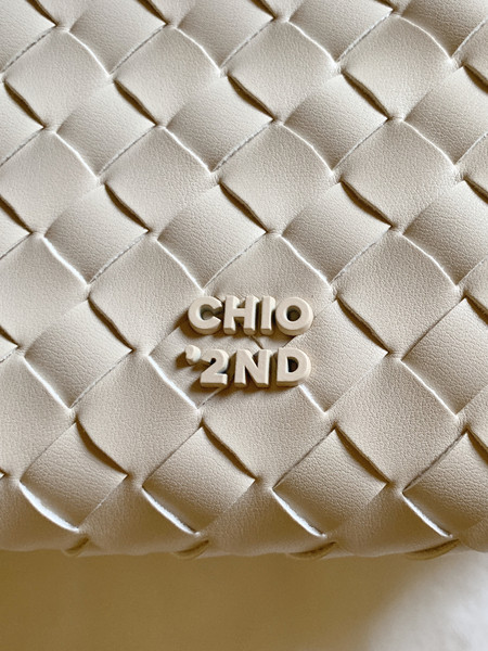 Close-up of a woven beige leather bag with CHIO'2ND branding