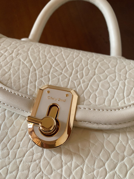Cream quilted leather handbag with gold-tone clasp and handle