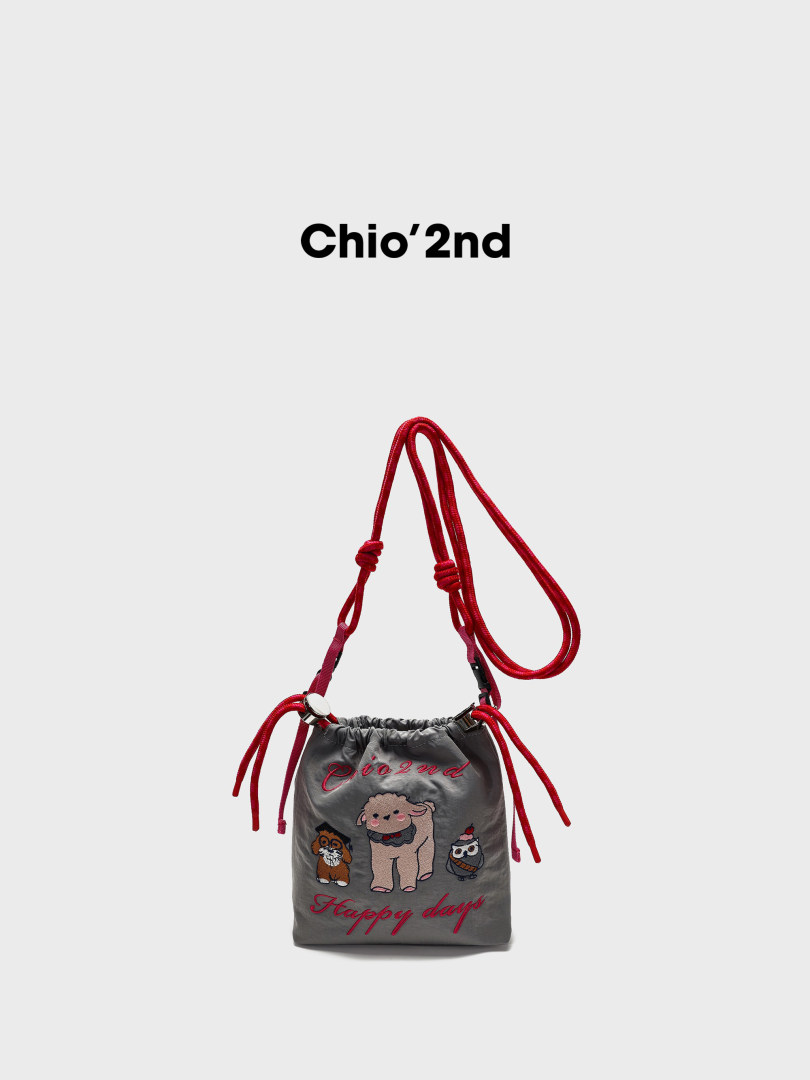 Gray drawstring shoulder bag with red straps and embroidered cartoon design