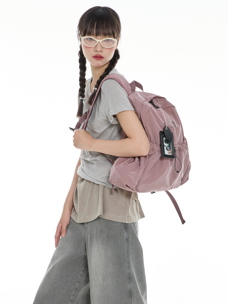 Pink backpack worn by a model on a white background