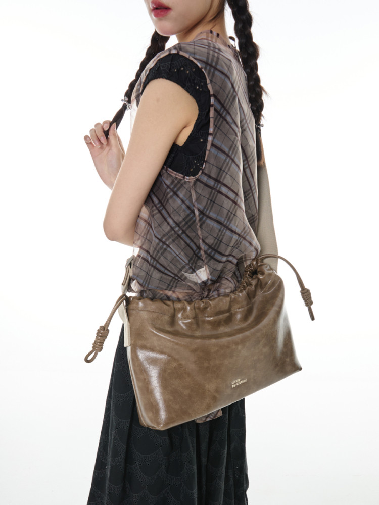 Brown slouchy shoulder bag worn by a model
