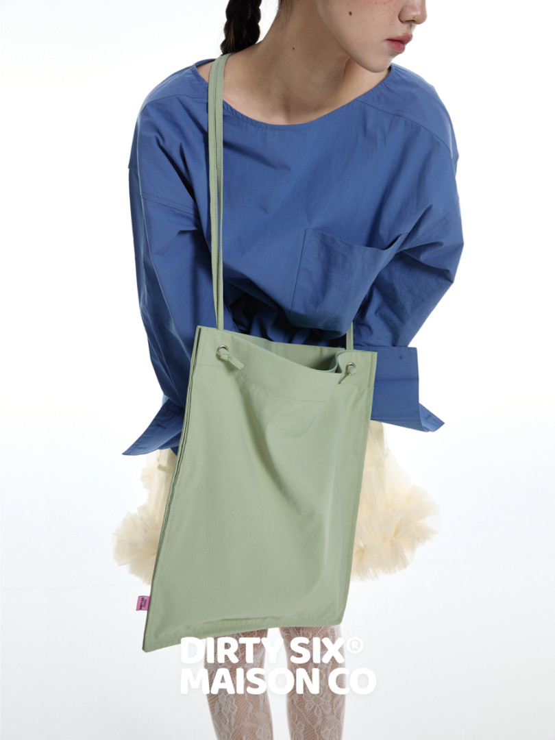 Light green minimalist shoulder tote bag worn on a model
