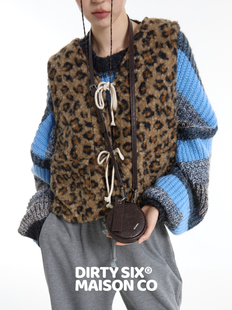 Model wearing a leopard-print knit vest over a striped sweater with a small round crossbody bag